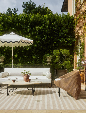 Orion handwoven neutral striped outdoor rug by Sarah Sherman Samuel paired with outdoor lounge furniture.