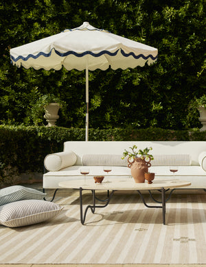 Outdoor patio lounge space featuring the Peggy sculptural iron frame and stone top oval outdoor coffee table.