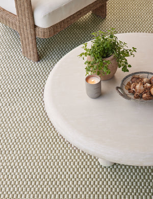 Round outdoor coffee table on top of the Dante handwoven checkerboard outdoor rug.