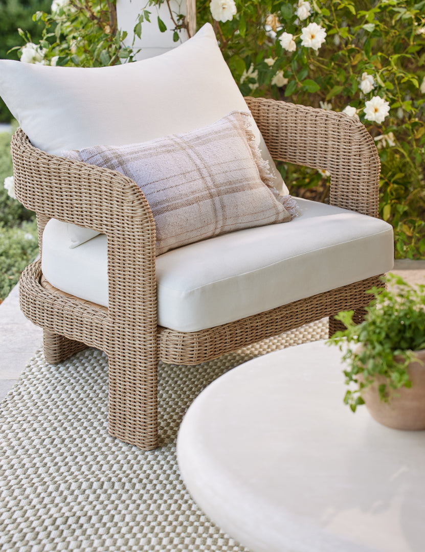 #color::natural | Hadler modern sculptural open frame wicker outdoor accent chair styled with a plaid outdoor throw pillow.