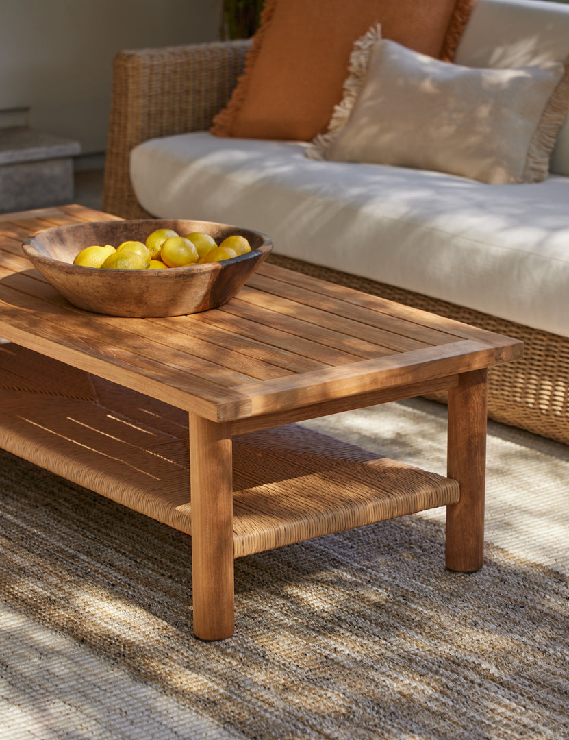 #color::natural | Gally teak and wicker outdoor coffee table styled with a large centerpiece bowl.