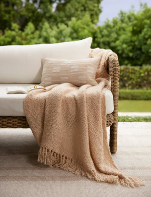 Leighton broken stripe lumbar pillow in terracotta styled on an outdoor sofa.