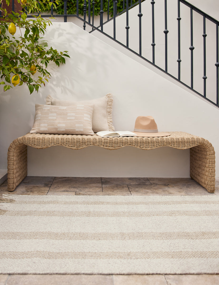 #color::natural #style::lumbar | The Leighton broken stripe lumbar pillow in natural styled on a wicker outdoor bench.