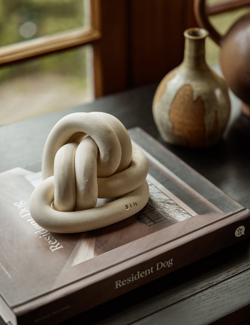 #color::white | Decorative ceramic double coil XL Fist Knot by SIN Ceramics styled on a tabletop
