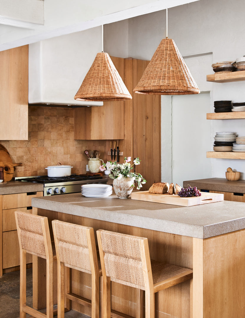 #color::natural | Angled view of the Maritza armless light wood and woven seagrass coastal style counter stool.