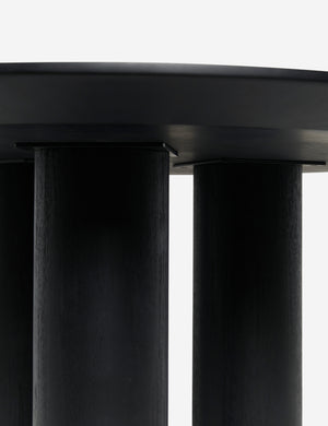 Close up view of the pillar legs of the Mojave round minimalist dining table in black.