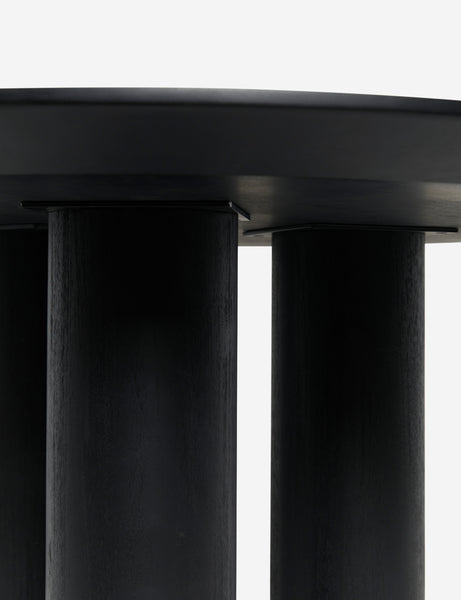 #color::black | Close up view of the pillar legs of the Mojave round minimalist dining table in black.
