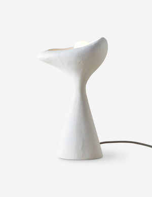 Odette matte white sculptural table lamp with light turned on