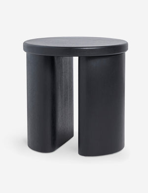 Angled view of the Olga round modern black oak side table