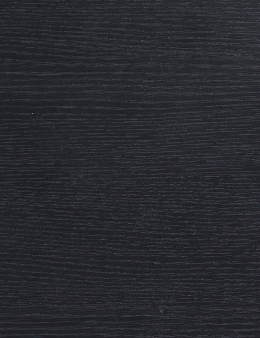 | Close up view of the black oak wood grain of the Olga round side table