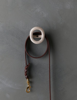 The olo white speckled wall hook with a leash hanging from it