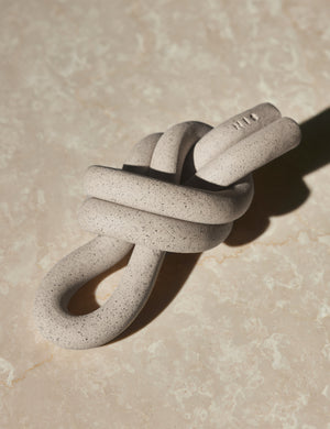 Angled view of the Overhand natural speckled ceramic Knot decorative object by SIN