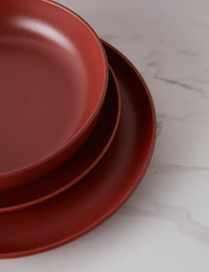A bowl and two plates that are part of the Cayenne red Pacifica Dinnerware (18-Piece Set) by Casafina stacked