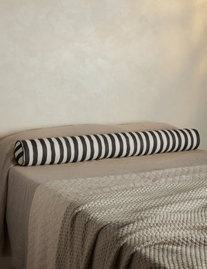 Painterly stripe linen long bolster throw pillow in black and ivory styled on a bed