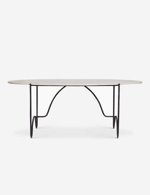 Side view of the Peggy sculptural iron frame and stone top oval outdoor dining table.