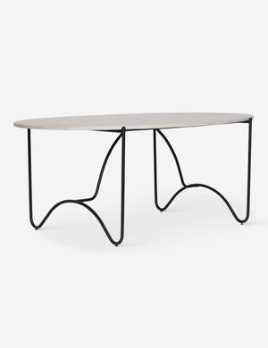 Peggy sculptural iron frame and stone top oval outdoor dining table.