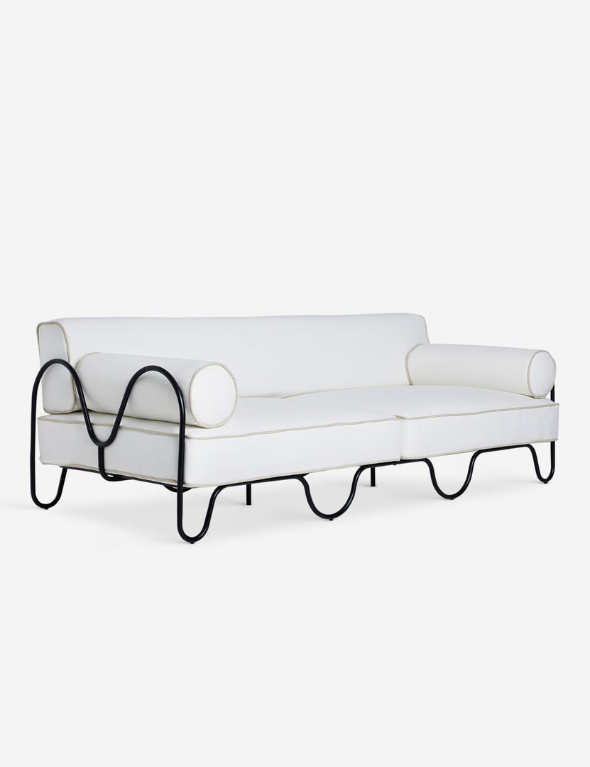 #color::ivory | Angled view of the Peggy sculptural iron frame and white cushion outdoor sofa.