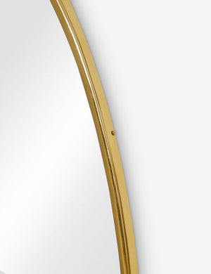 The gold curved frame on the large puddle mirror