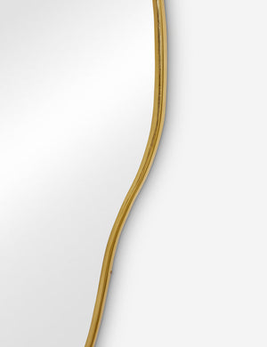 The gold curved frame on the large puddle mirror