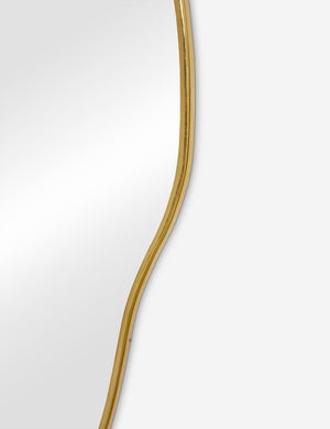 The gold curved frame on the large puddle mirror