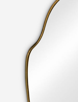 The gold curved frame on the large puddle mirror