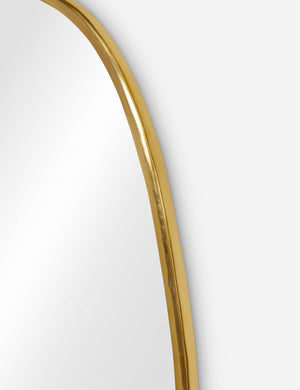 The gold curved frame on the small puddle mirror