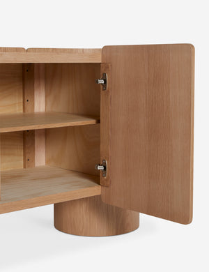 Close up view of the Raphael modern rounded honey oak sideboard cabinet with the doors open