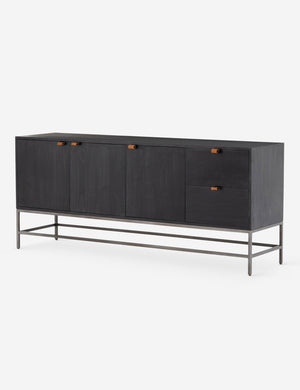 Angled right side view of the Rosamonde black wood sideboard with brown leather pulls and a metal base