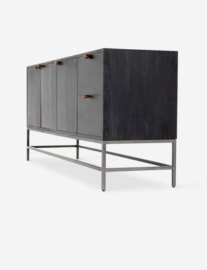 Right side view of the Rosamonde black wood sideboard with brown leather pulls and a metal base