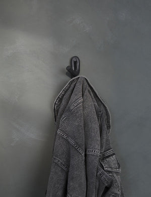 Black Leggy Crossed Wall Hook by SIN Ceramics with a black jean jacket hanging on it