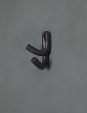 Black Leggy Crossed Wall Hook by SIN Ceramics hanging on a gray wall