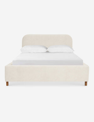 Solene Boucle Cream platform bed with an arched headboard and oak wood legs