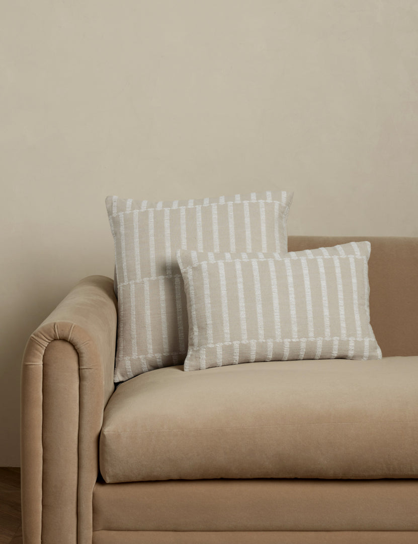 #color::ivory-and-natural #style::square #style::lumbar | Thisbe offset stripe throw and lumbar pillows paired together on a sofa.