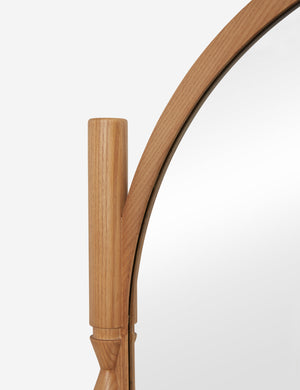 Close up of the top of the Topia arched carved wood frame floor mirror by Ginny Macdonald in natural.