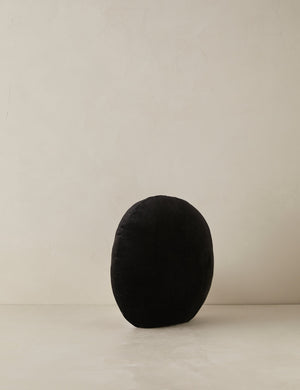 Angled view of the Velvet round accent pillow in black