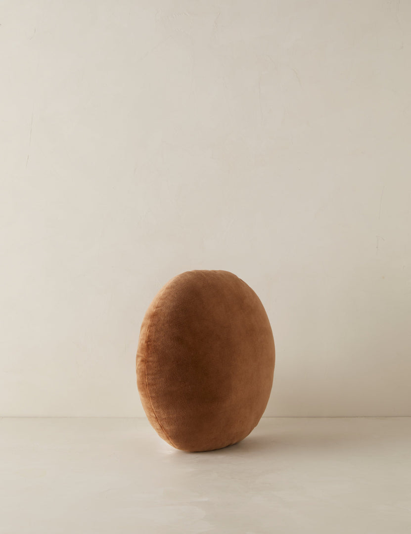 #color::umber | Angled view of the Velvet round accent pillow in rust umber