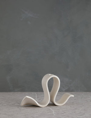 Whit white Candelabra by SIN with an undulating silhouette and space for one taper candle