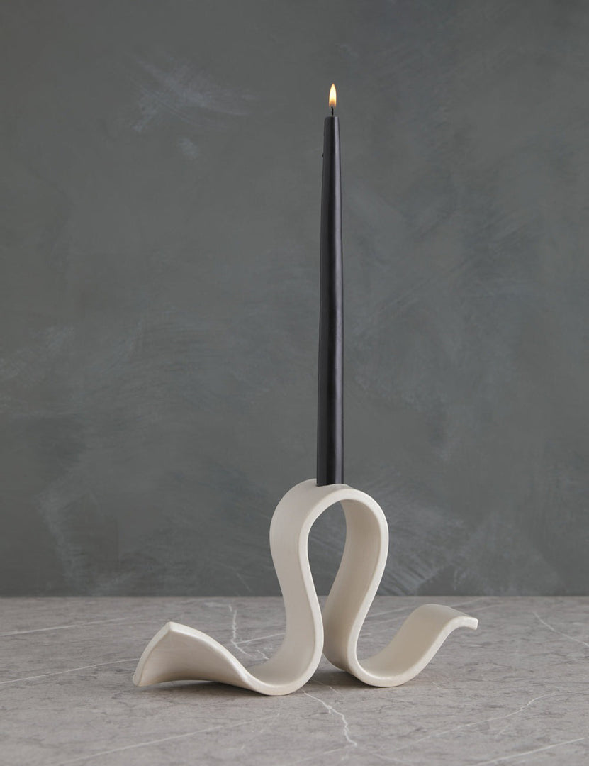| Whit white Candelabra by SIN with an undulating silhouette and a black taper candle