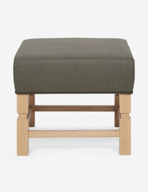 Ambleside Loden gray linen upholstered ottoman by Ginny Macdonald with a carved frame and vertical channeling on the cushion