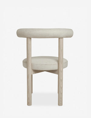 Rear view of the Dame minimalist rounded open-back dining chair with ivory upholstered seat and ash wood frame