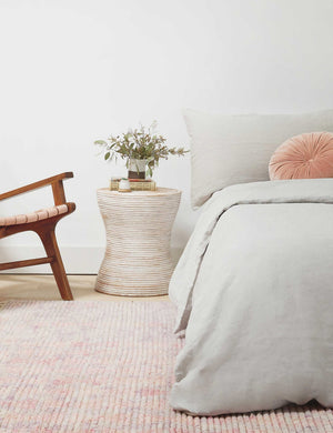 Fenne round ribbed stone side table styled as a bedside table.