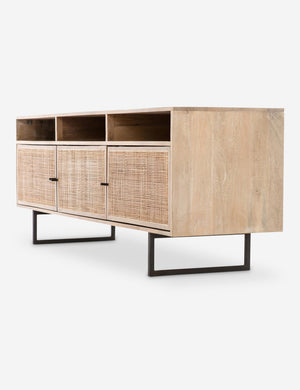 Angled view of the Hannah natural mango wood media console with cane doors.