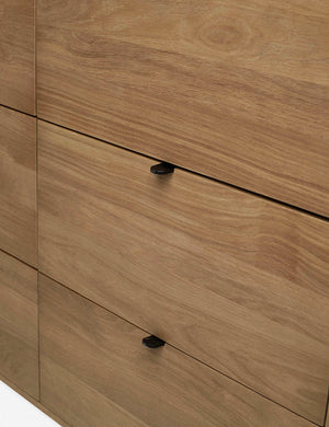 The meta drawer pulls of the Kono 6-drawer curved oak wide dresser.