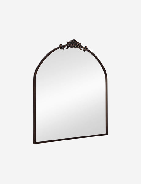 #color::oil-rubbed-bronze | Angled view of the Tulca arched oil rubbed bronze mirror with flat bottom edge and traditional scroll detailing.