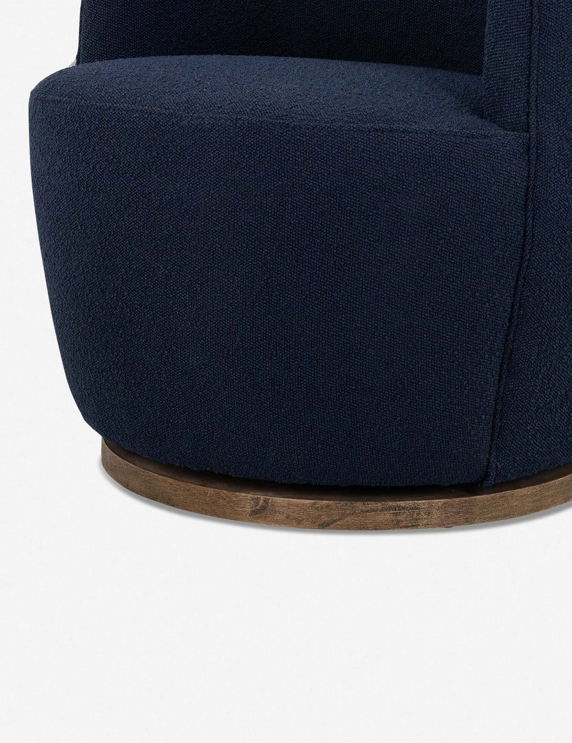 #color::navy | Close-up of the swivel base and fabric for the Margie rounded barrel swivel accent chair in navy