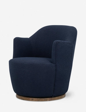 Angled side view of Margie rounded barrel swivel accent chair in navy