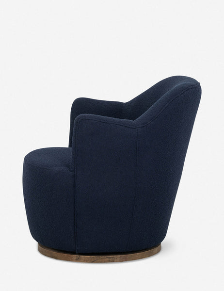 #color::navy | Side view of Margie rounded barrel swivel accent chair in navy