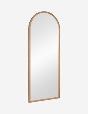 Angled view of the Paisley arched light wood framed floor mirror.