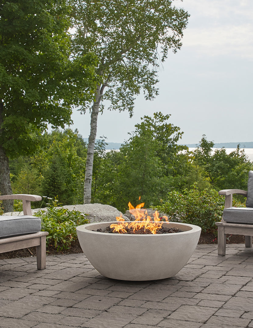 #color::fog #size::38- #configuration::propane | The Benno fog fire bowl sits in an outdoor space next to outdoor lounge furniture