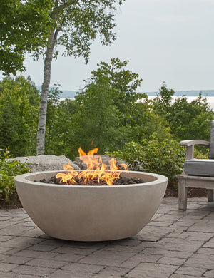 The Benno fog fire bowl sits in an outdoor space next to outdoor lounge furniture